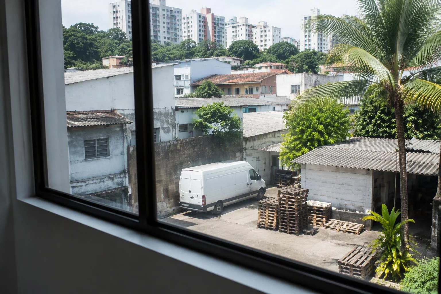 Janela de escritório com vista para o pátio de uma pequena fábrica